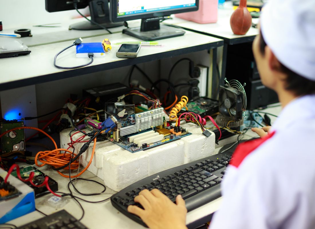 A technician dismantling and inspecting IT equipment at the processing bench