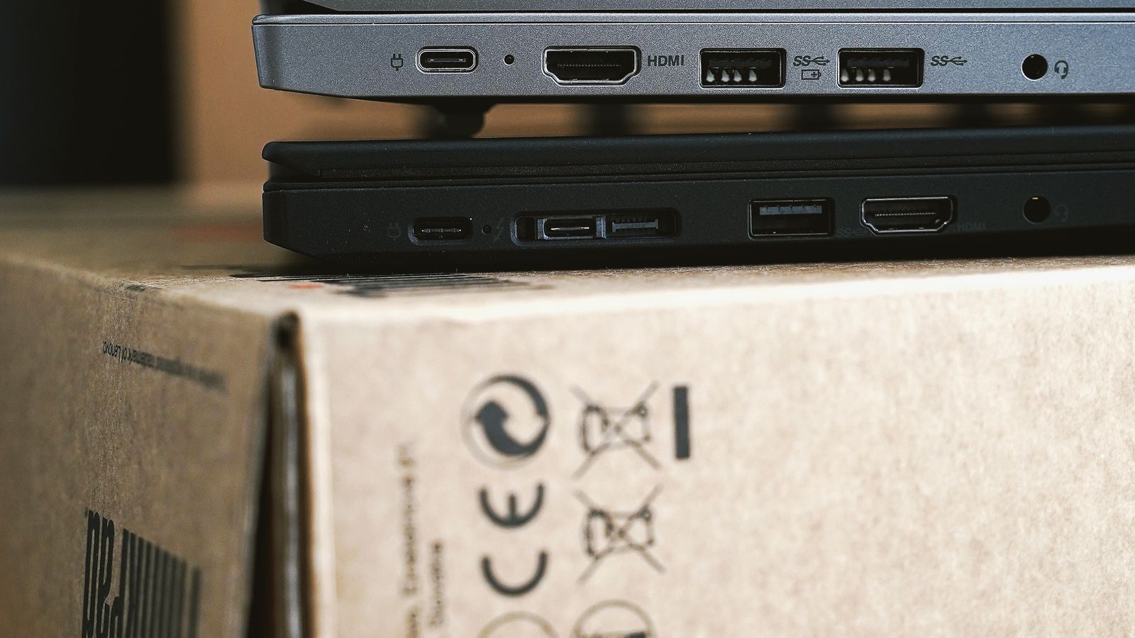 Retired laptops stacked on a recycling box — disposed IT assets we collect and recover